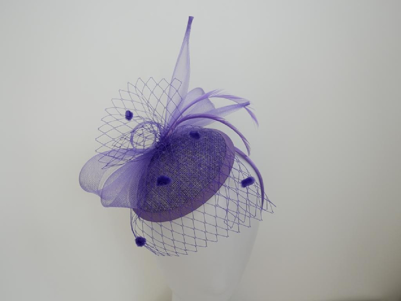 Liliowy fascynator z woalką i piórami na przepasce