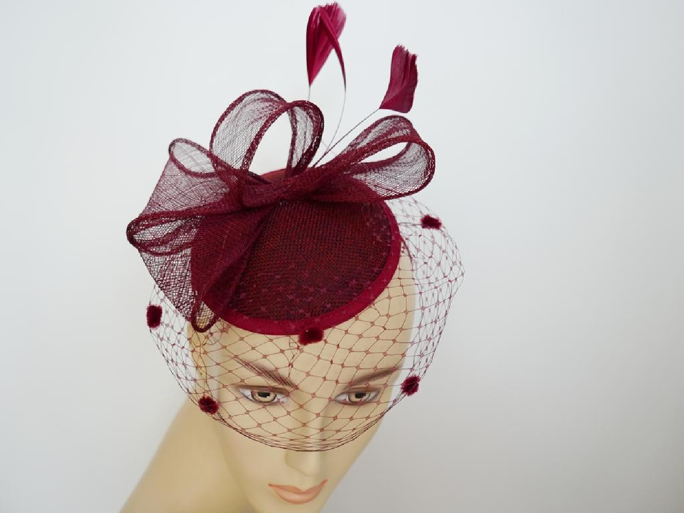 Bordowy fascynator z woalką i piórami na przepasce