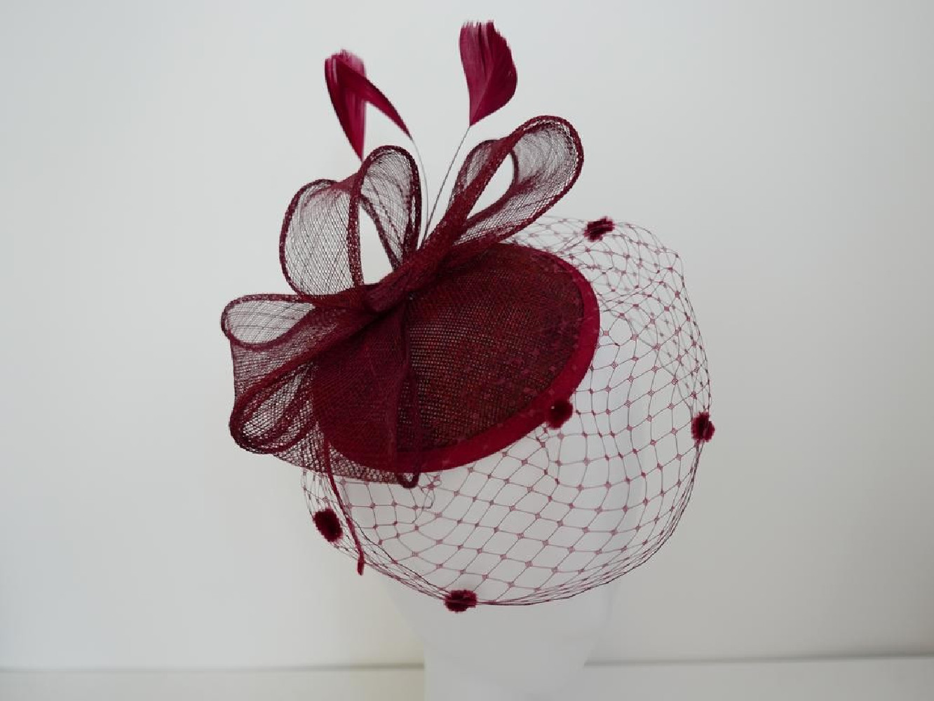 Bordowy fascynator z woalką i piórami na przepasce