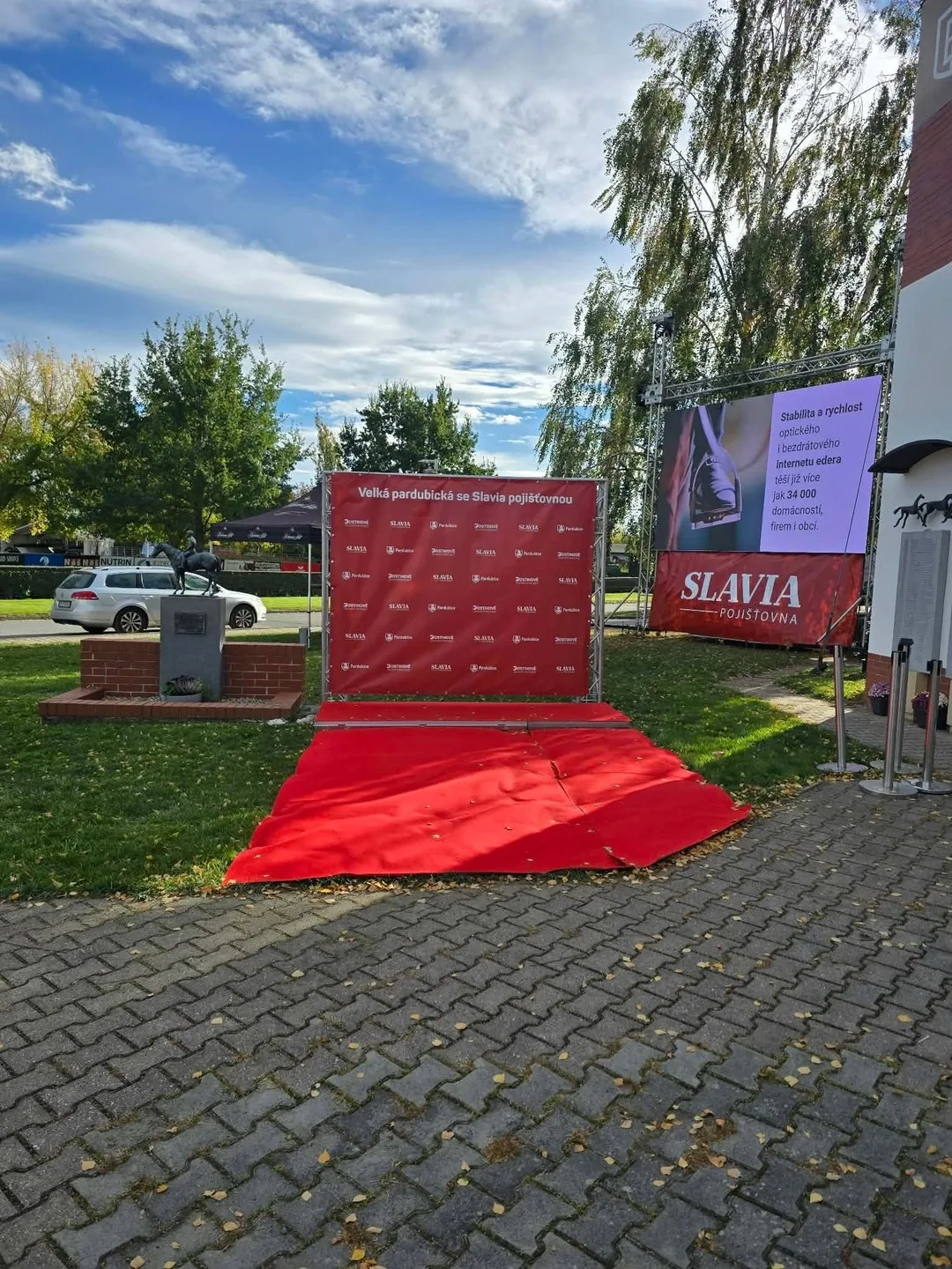 Czerwony dywan i ścianka Wielkiej Pardubickiej przy wejściu na tor.